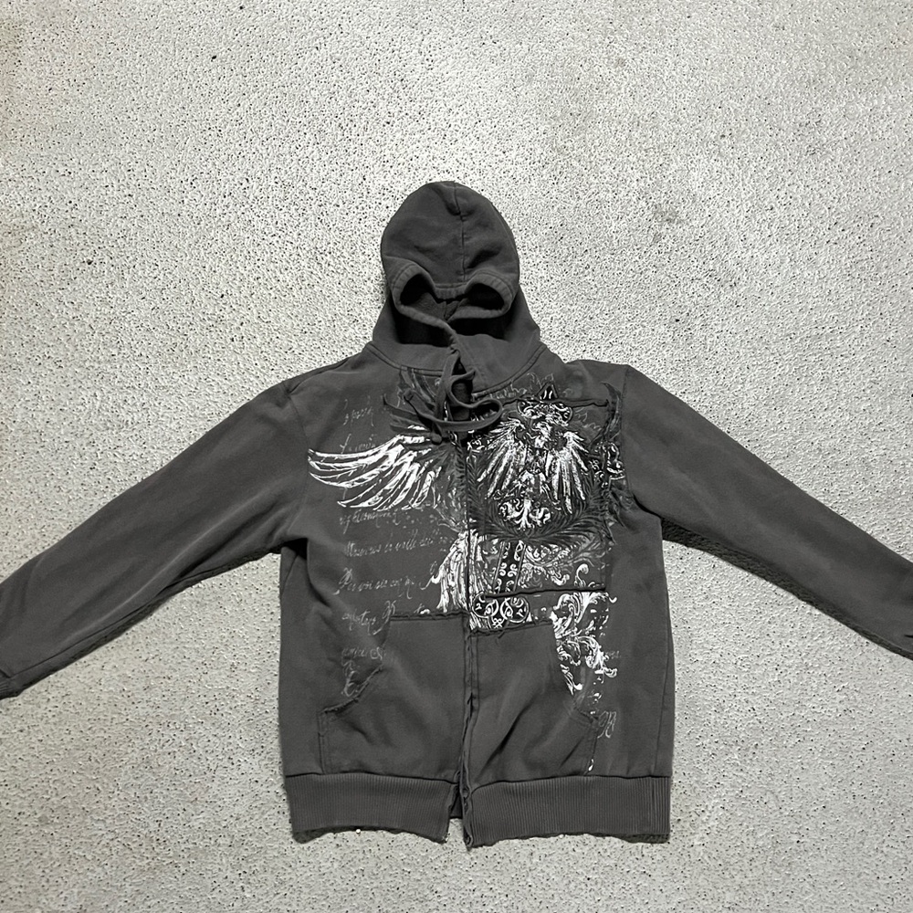 Grey and white zip-up hoodie with cross, wings, and flames design